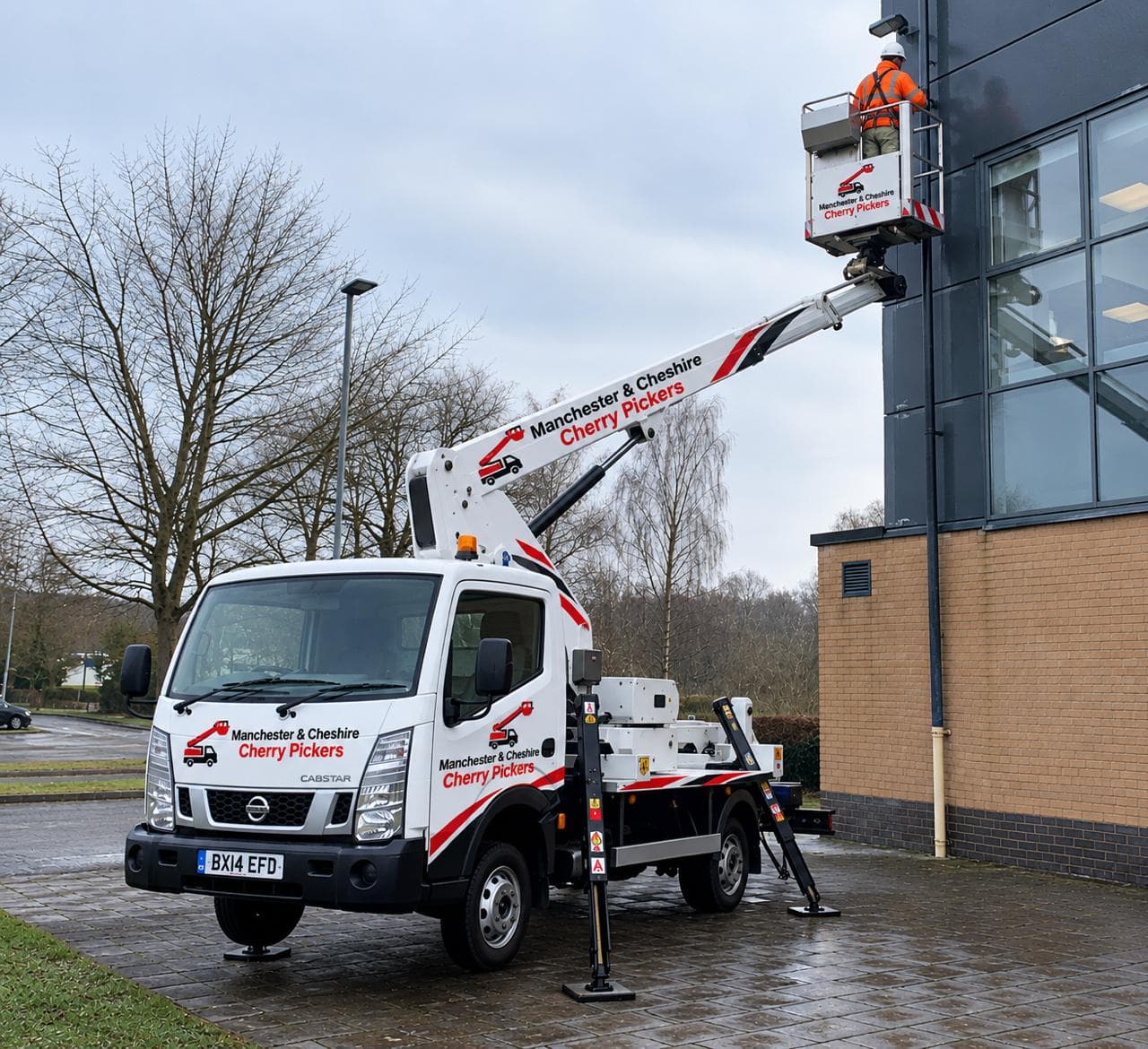 Manchester & Cheshire Cherry Pickers operator working at height from a 21m truck-mounted cherry picker