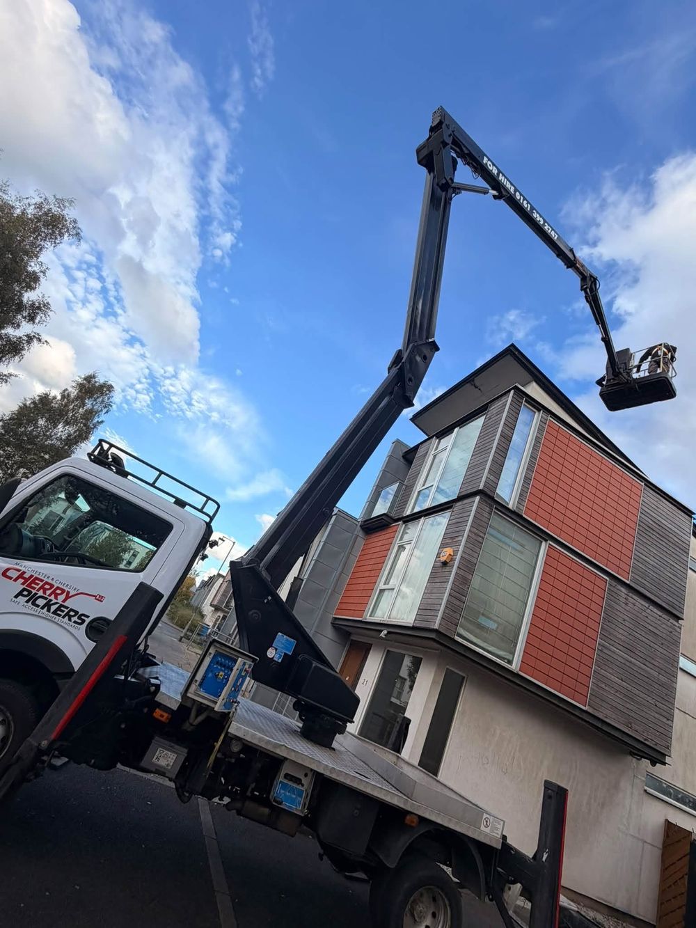 Cherry picker reaching the top floor of a townhouse